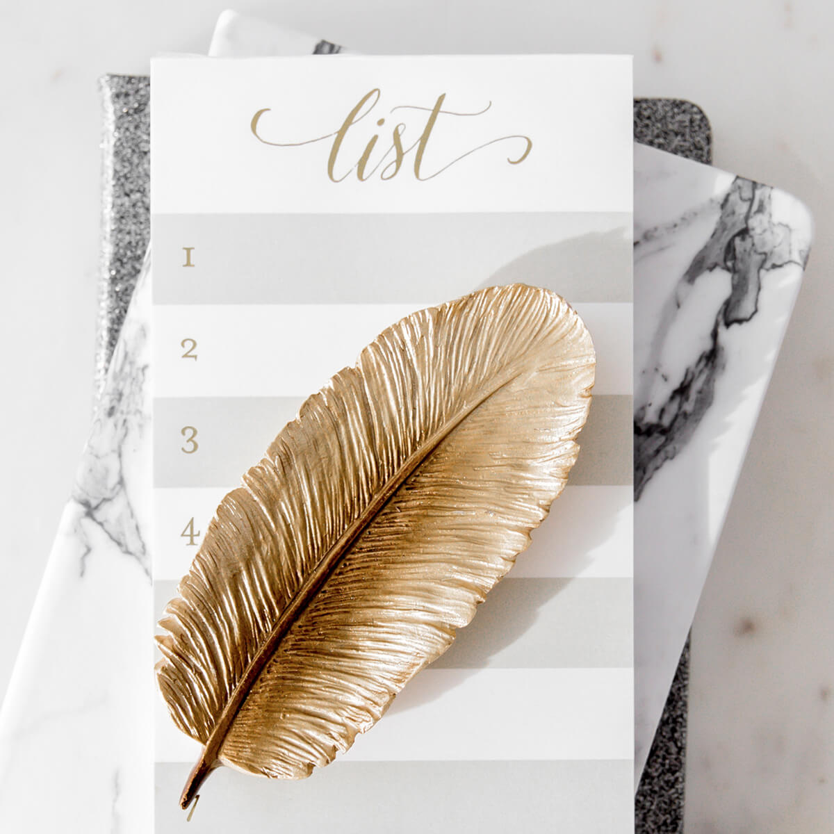 gold feather on notepad